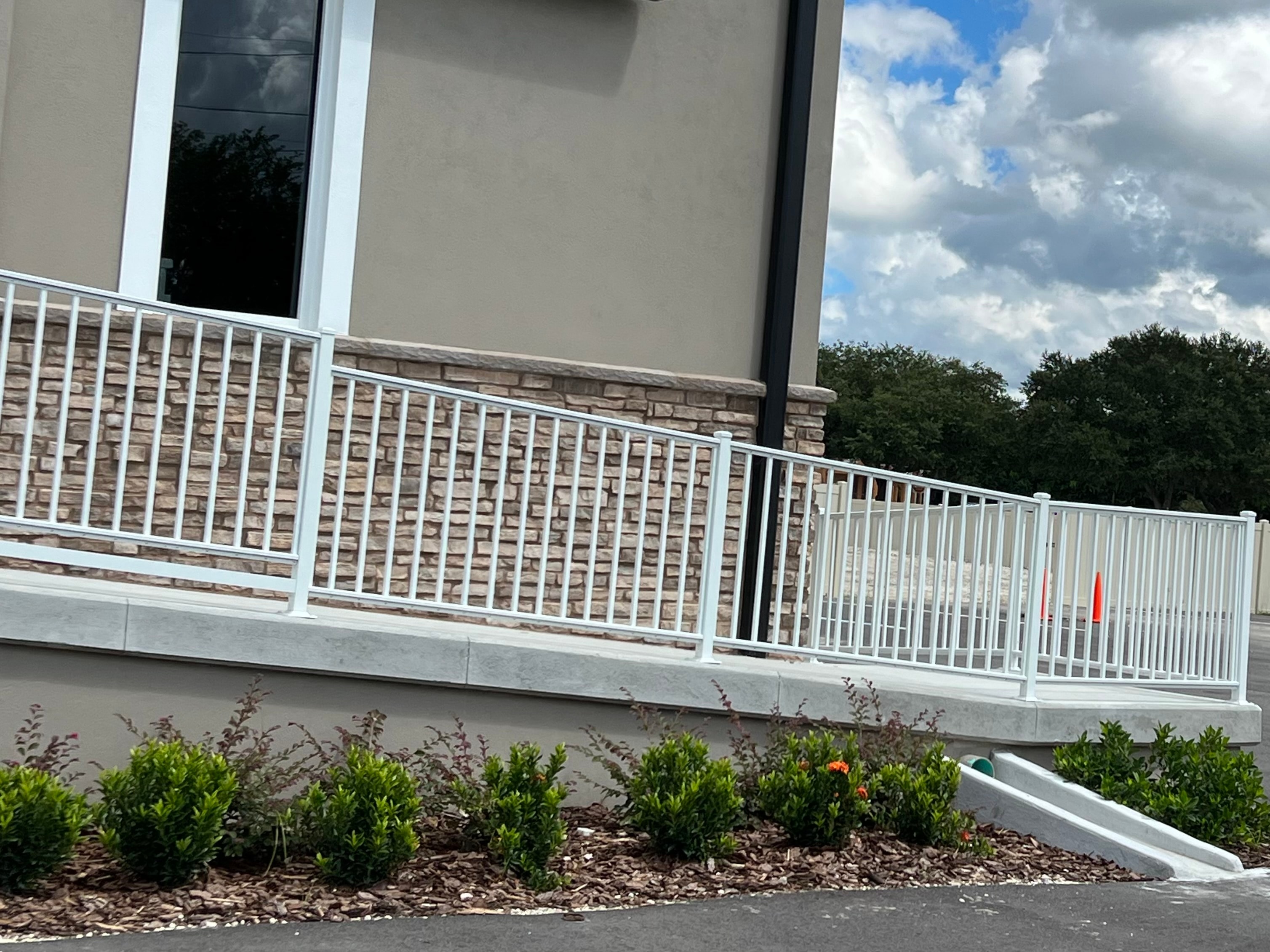 White ARM railing close-up on stone facade commercial install